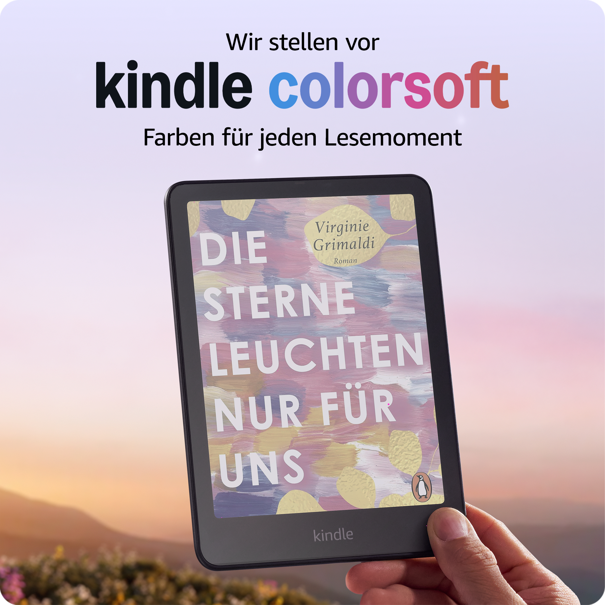 Eine Hand hält einen Kindle, der ein Buchcover zeigt. Der Hintergrund zeigt einen Sonnenuntergang über Bergen.