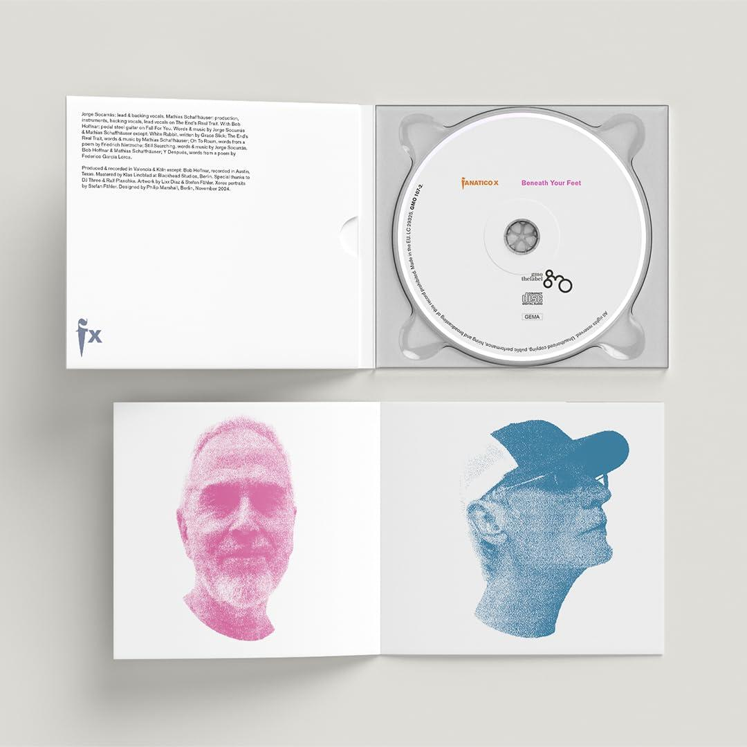 Geöffnete CD-Verpackung, mit CD und Booklet. Ein Booklet zeigt das Gesicht eines Mannes. Das andere zeigt eine blaue Figur eines Mannes.