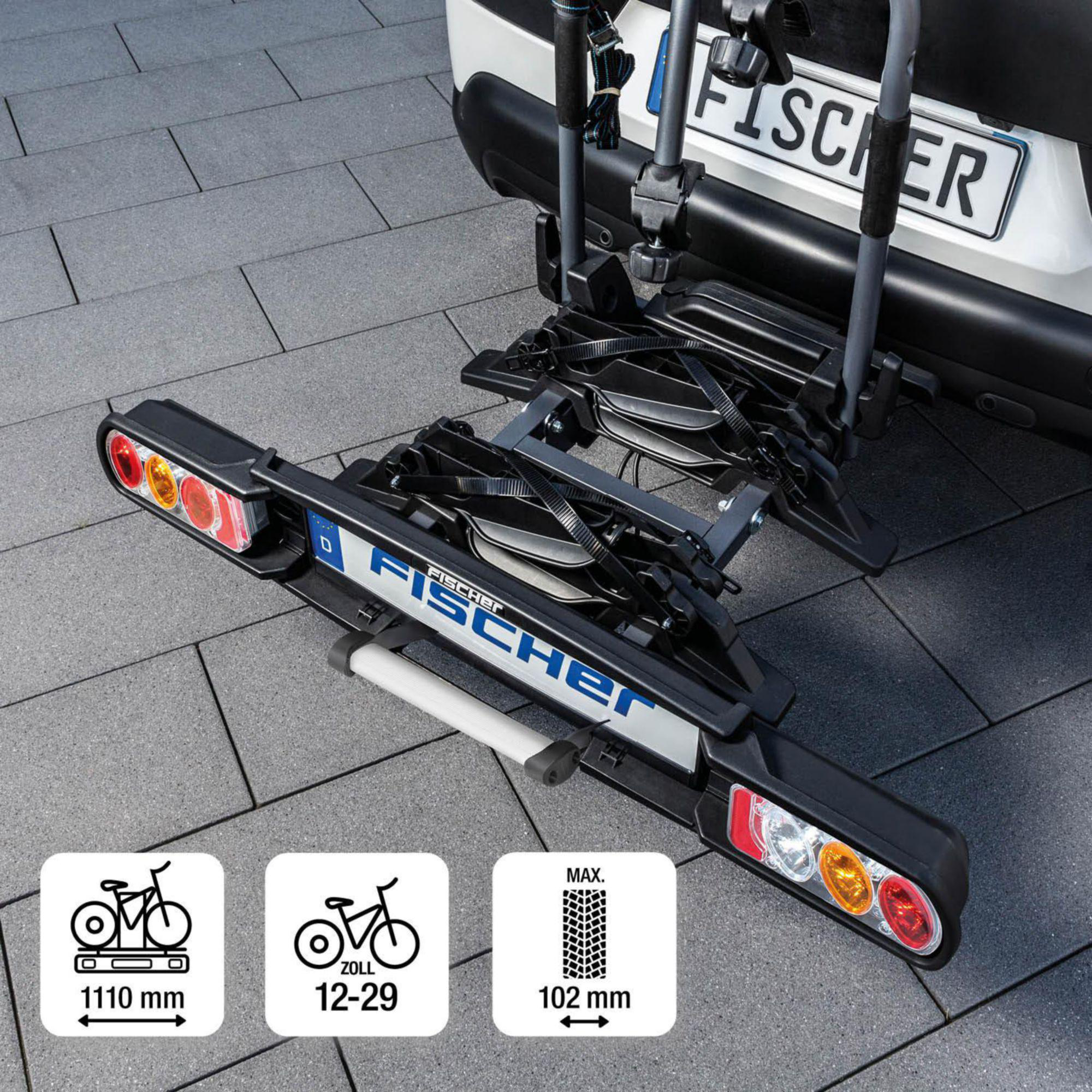 Schwarzer Fischer-Fahrradträger an einem weißen Fahrzeug. Er hat Lichter und ein Kennzeichen. Drei Diagramme sind ebenfalls abgebildet.
