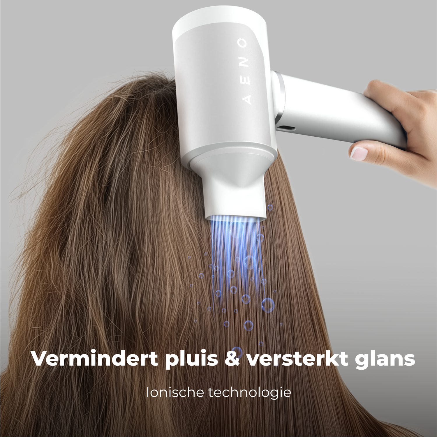 A white hair dryer is used on brown hair. Blue light and bubbles emanate from the dryer. Text reads 'Reduces frizz & enhances shine'.