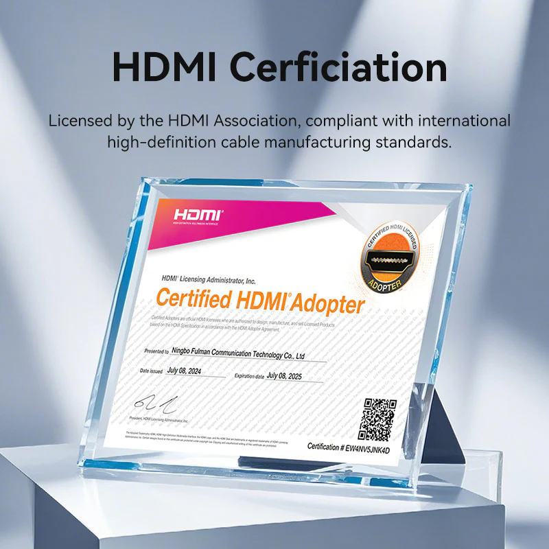 HDMI tanúsítás. Egy átlátszó akril keret egy minősített HDMI adapter tanúsítványát mutatja. A szöveg részleteket és QR-kódot tartalmaz.