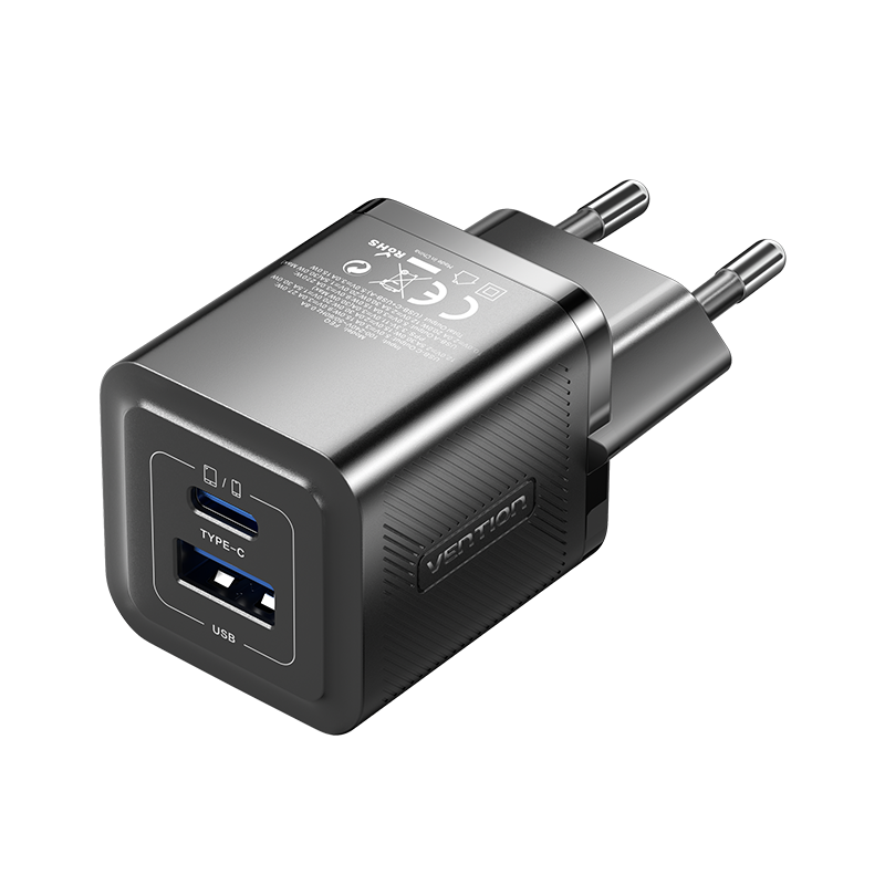 Egy fekete Vention USB-töltő Type-C és USB portokkal, két ezüst dugóval, fekete háttéren.