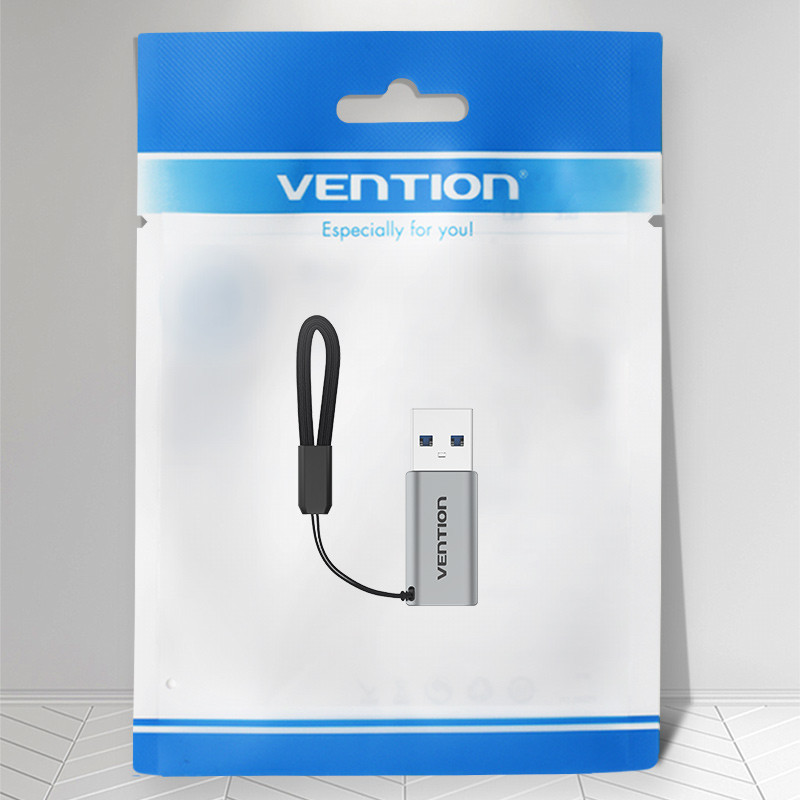 Vention USB meghajtó a csomagolásban. Az egység ezüstszínű, fekete pánttal. A csomagolás fehér és kék.