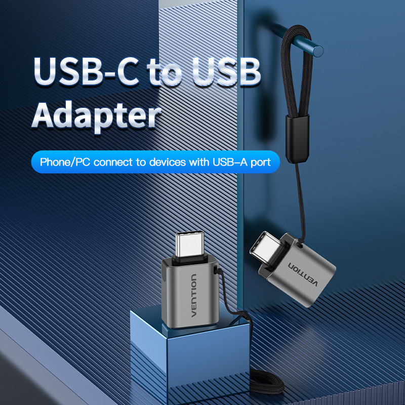 Egy USB-C–USB-adapter kék felületen. Az adapter szürke, VENTION márkájú. A szöveg a következő: USB-C–USB-adapter.
