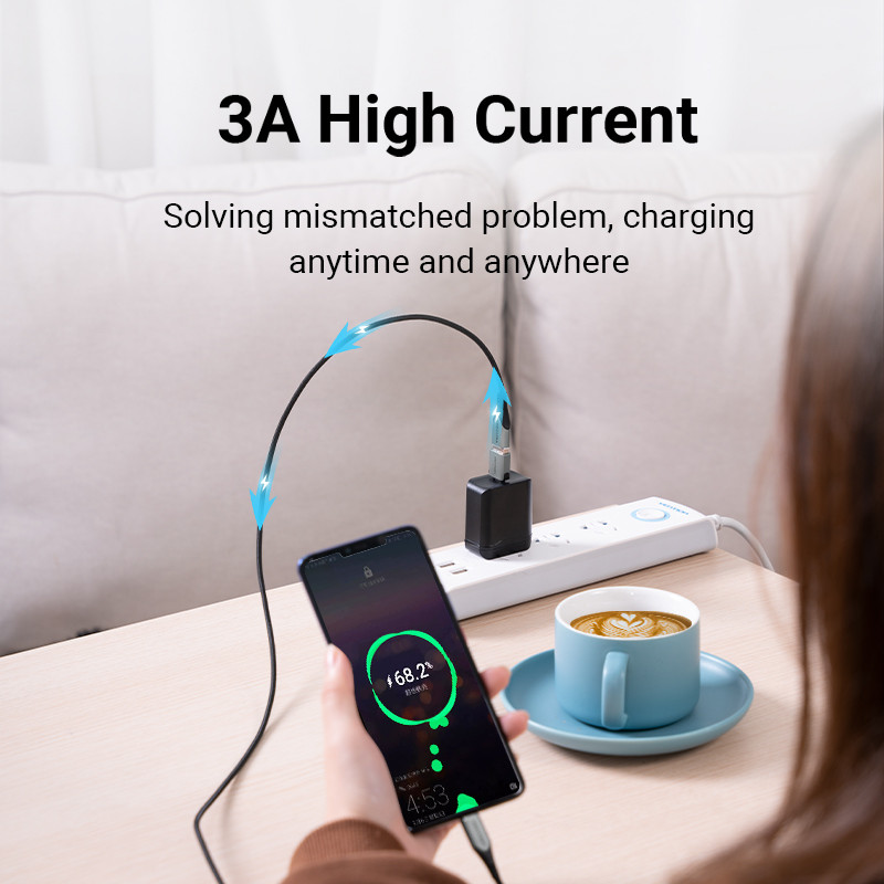 Egy telefon töltődik. Egy kéz tartja a telefont, ami 68,2%-os töltöttséget mutat. Egy fekete kábel csatlakozik a töltőhöz.