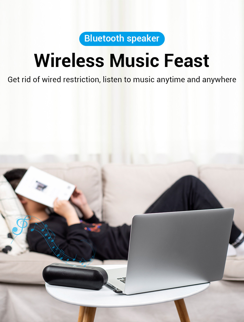 Egy személy a kanapén olvas egy könyvet. Egy laptop, egy hangszóró és zenei jegyzetek vannak az asztalon. A szöveg szerint 'Wireless Music Feast'.