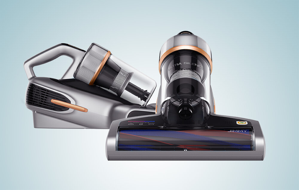 Dwa bezprzewodowe odkurzacze. Srebrny i czarny ze miedzianymi akcentami. Jeden jest ustawiony pod kątem, drugi stoi prosto. Oba mają przezroczyste pojemniki na kurz.