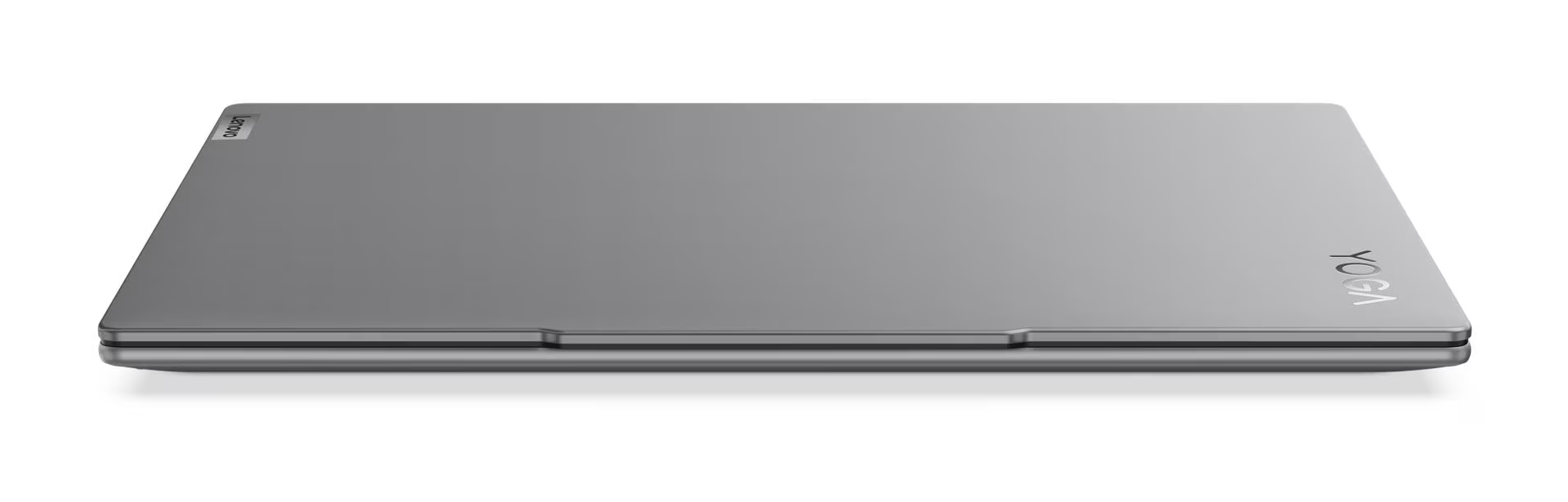Zamknięty, szary laptop Lenovo Yoga jest lekko pochylony. Logo Yoga jest widoczne po prawej stronie. Logo Lenovo jest po lewej.
