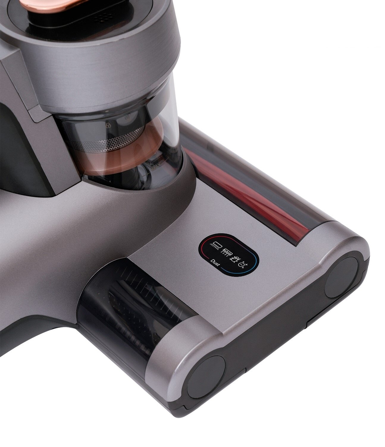 Zbliżenie szarej głowicy odkurzacza. Ma pojemnik na kurz i dyszę z czerwoną szczotką. Obudowa ma wyświetlacz i przyciski.