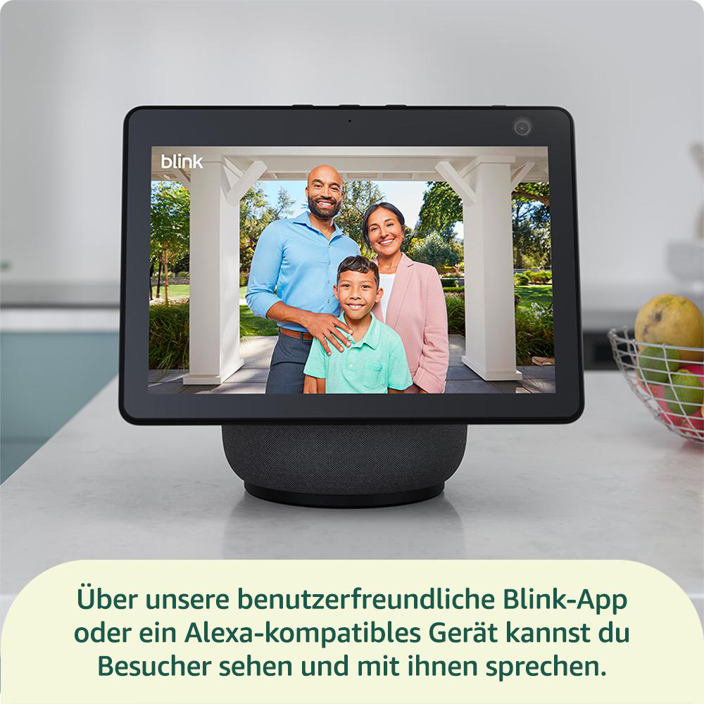 Tablet zeigt eine dreiköpfige Familie. Es steht auf einem Sockel. Text unten: 'Besucher sehen und mit ihnen sprechen'.