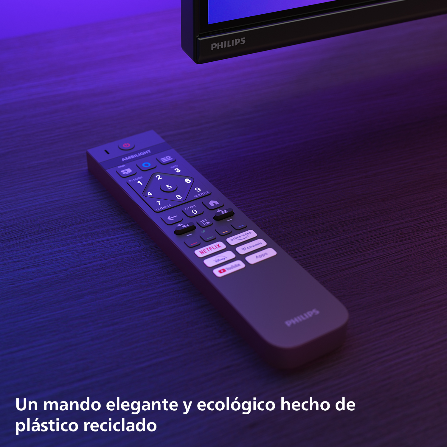 Un mando Philips gris oscuro sobre madera. Un TV en la esquina superior derecha. Texto: 'plástico reciclado'.