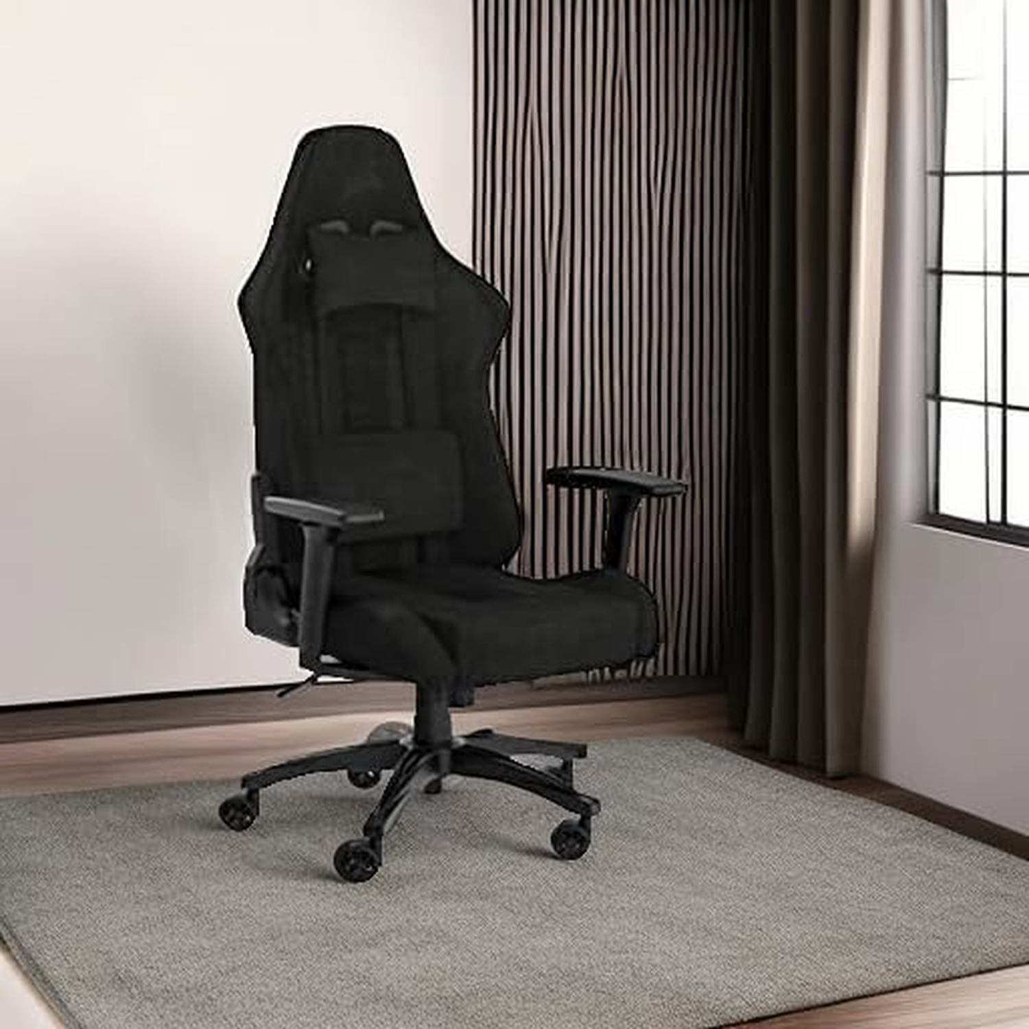 A black gaming chair sits on a gray rug. Background includes a striped wall, curtains, and a window.