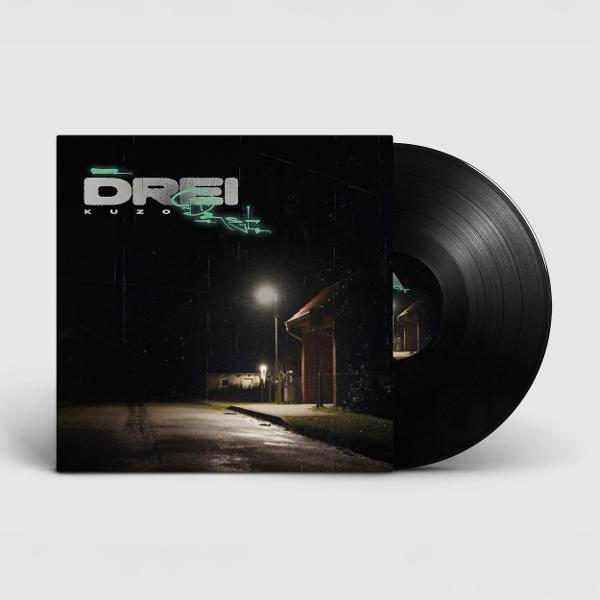 Vinylplatte mit Albumcover. Dunkle Straßenszene mit Neontext 'DREI'. Eine Straßenlaterne beleuchtet ein Gebäude.