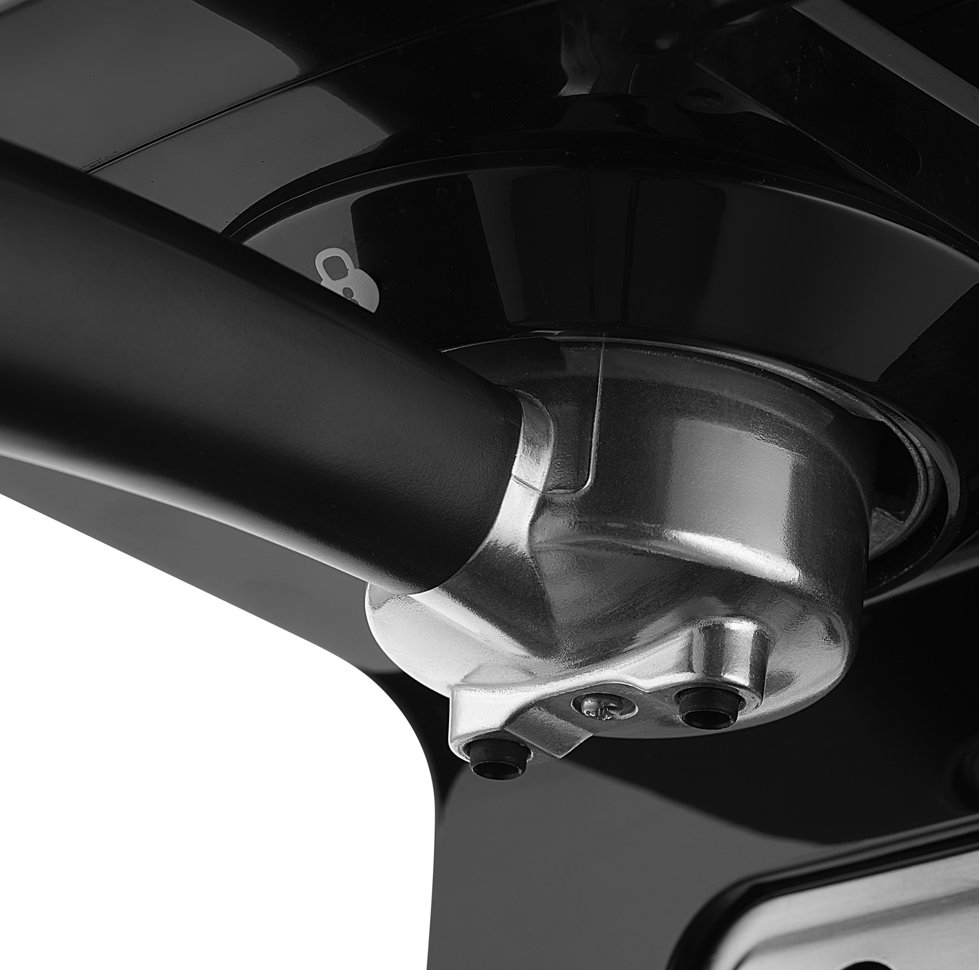 Zbliżenie czarnej części maszyny ze srebrnym metalowym elementem i czarną rurką.