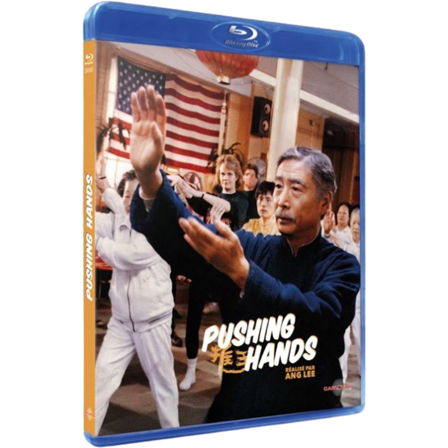 Jaquette Blu-ray de Pushing Hands. Un homme en bleu pratique les arts martiaux. Le drapeau américain est en arrière-plan. Autres personnes.