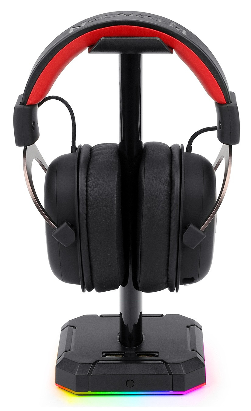 Czarne słuchawki dla graczy z czerwonymi akcentami na czarnym stojaku. Podstawa ma porty USB i światła LED.
