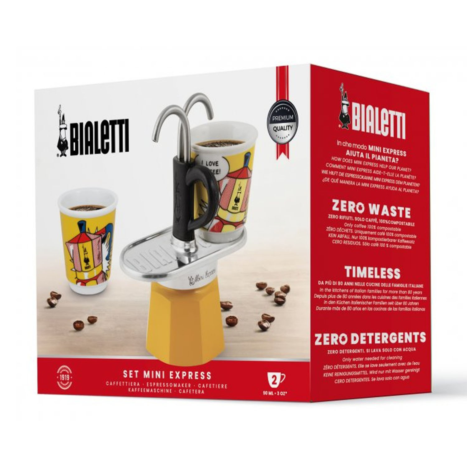 Un set Bialetti Mini Express con due tazze, caffettiera e chicchi di caffè su legno. La confezione è sullo sfondo.