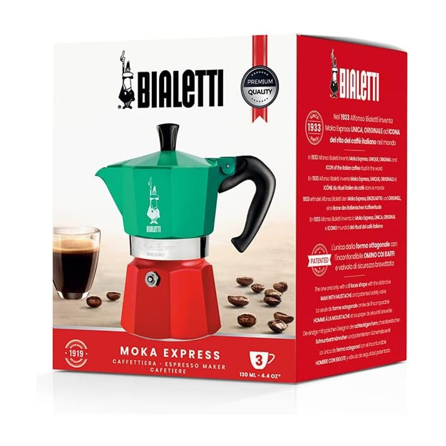 Caffettiera Bialetti Moka Express, base rossa, parte superiore verde, manico nero, tazza di caffè a sinistra, chicchi di caffè sparsi.
