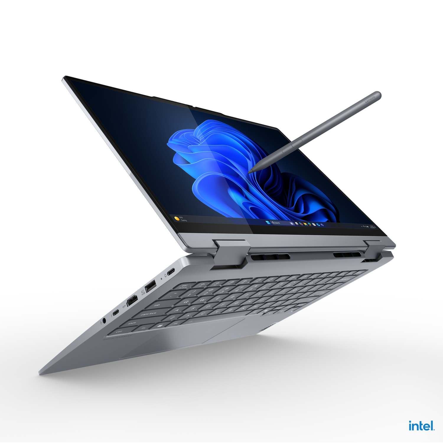 A silver laptop with a stylus pen, open on a black background. The screen shows a blue Windows background.