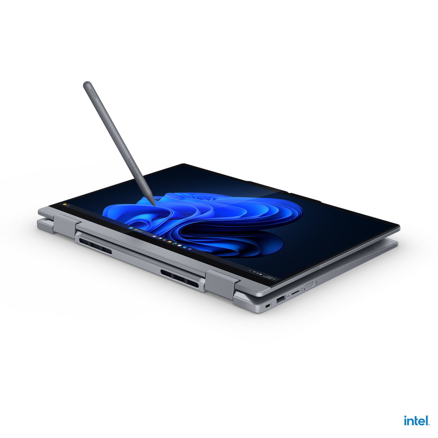 A silver laptop with a stylus hovering above its screen. The screen displays a blue, abstract design against a dark background.