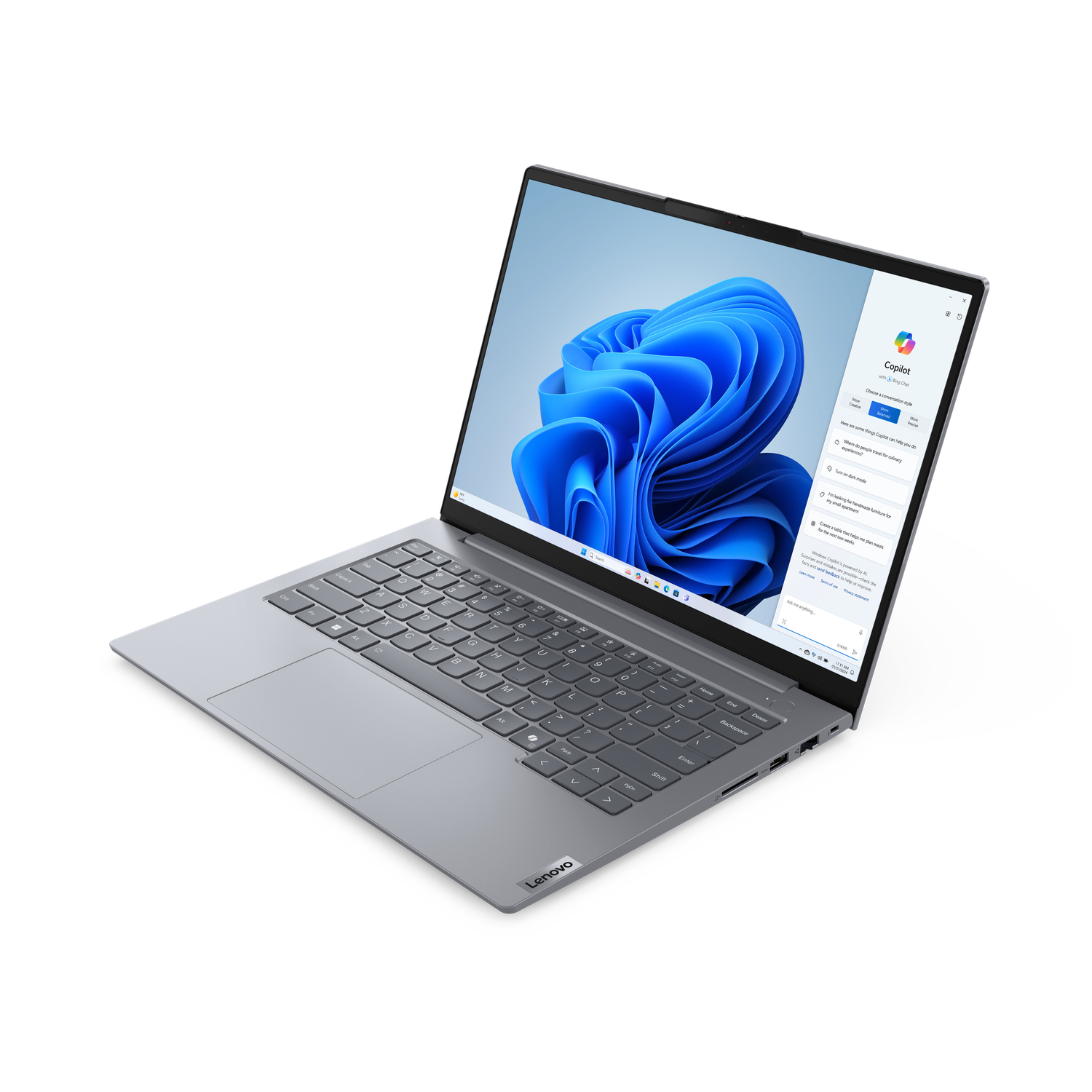 A silver Lenovo laptop is open. The screen displays a blue and white design and a Copilot window.