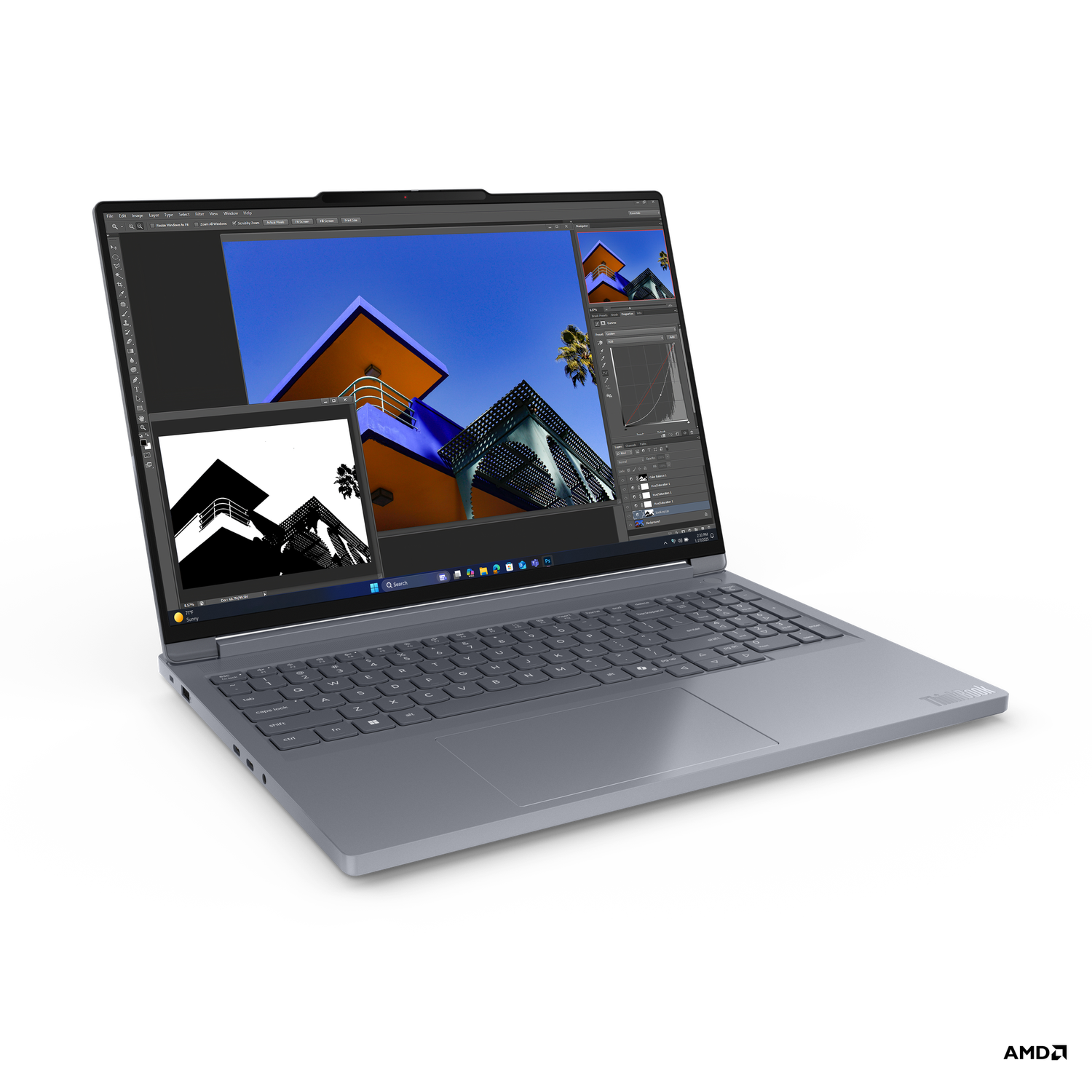 A gray laptop displays an image of a building with orange, blue, and white colors. The screen also shows editing software.