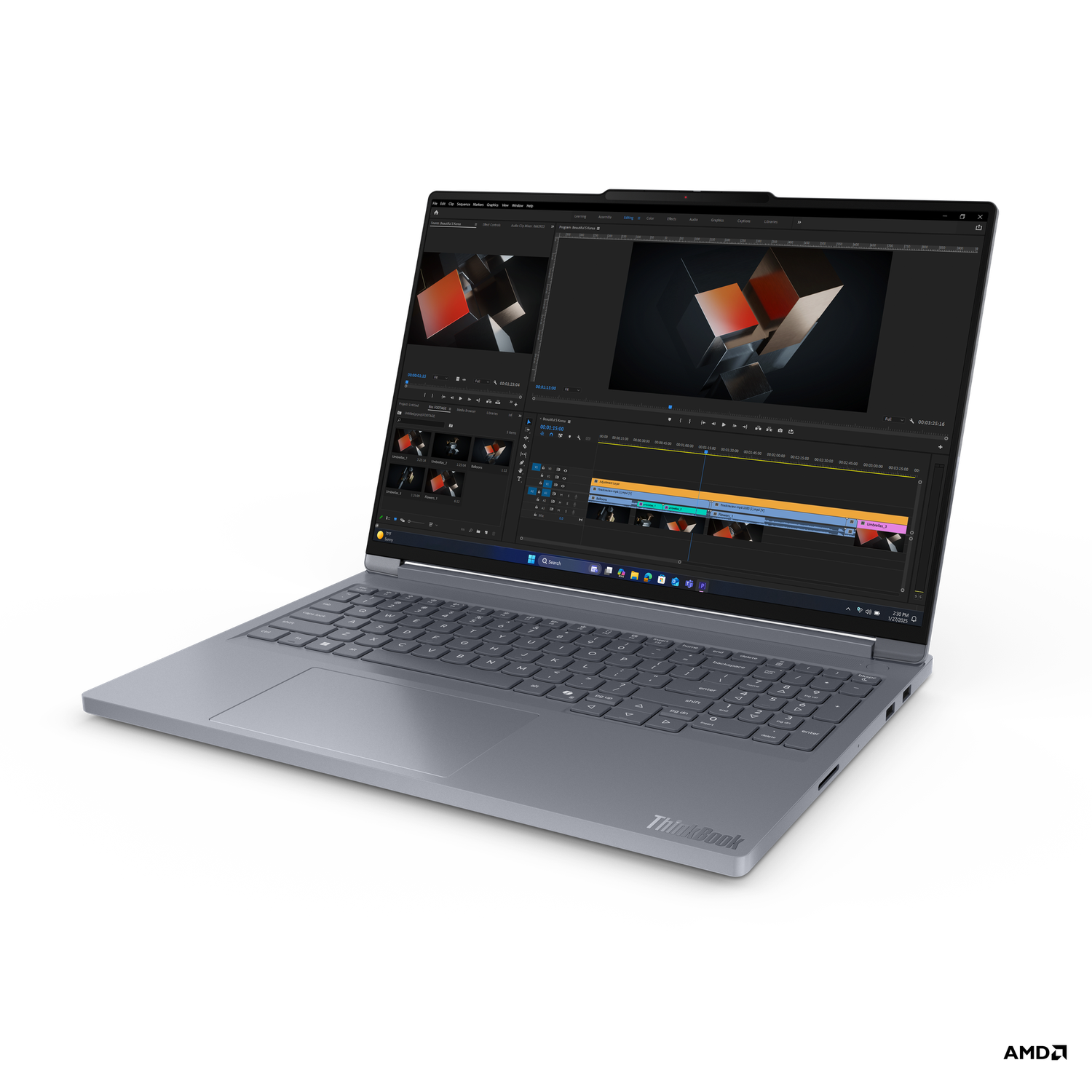 A gray laptop displays video editing software. The screen shows a timeline and video clips. The laptop sits on a black background.