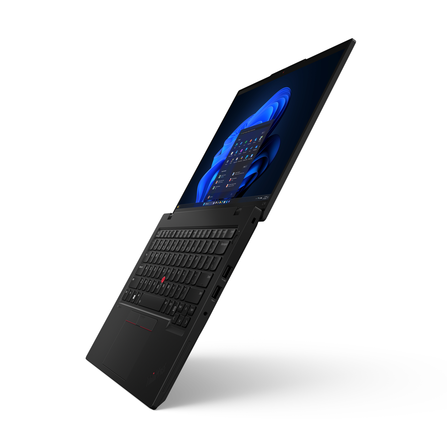 Ordinateur portable noir sur fond noir. L'écran affiche l'interface Windows. Clavier et pavé tactile visibles. Logo ThinkPad.