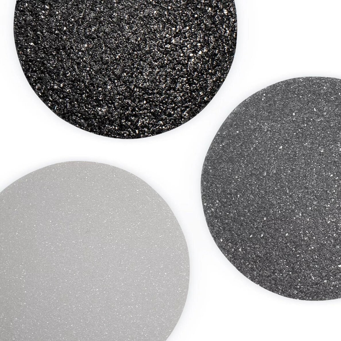 Trzy okrągłe kształty o teksturowanych powierzchniach: czarny, szary i jasnoszary, na białym tle.