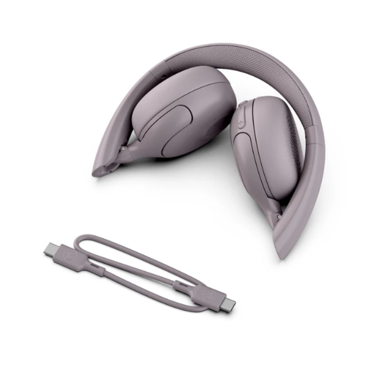 Opgevouwen, mauve koptelefoon en oplaadkabel op witte achtergrond. Koptelefoon is opgevouwen, met oorschelpen naar boven.