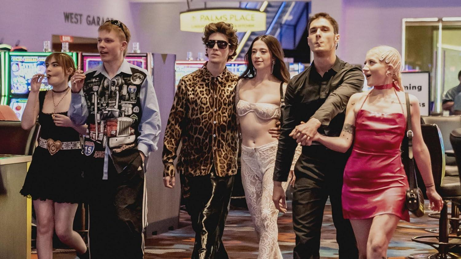 Fünf junge Leute gehen in einem Casino auf einem bunten Teppich.