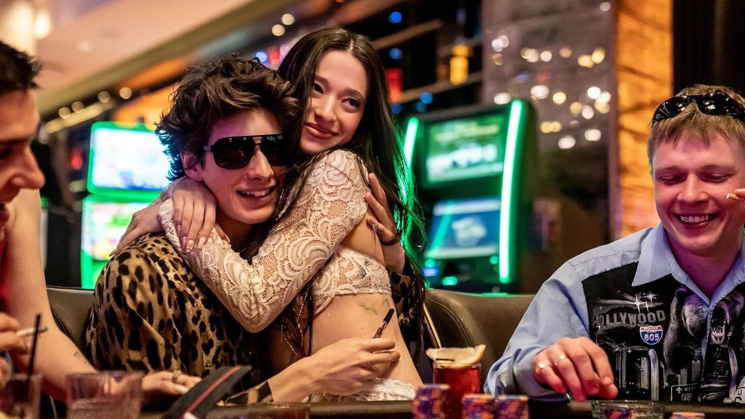 Ein Paar umarmt sich in einem Casino vor Spielautomaten.