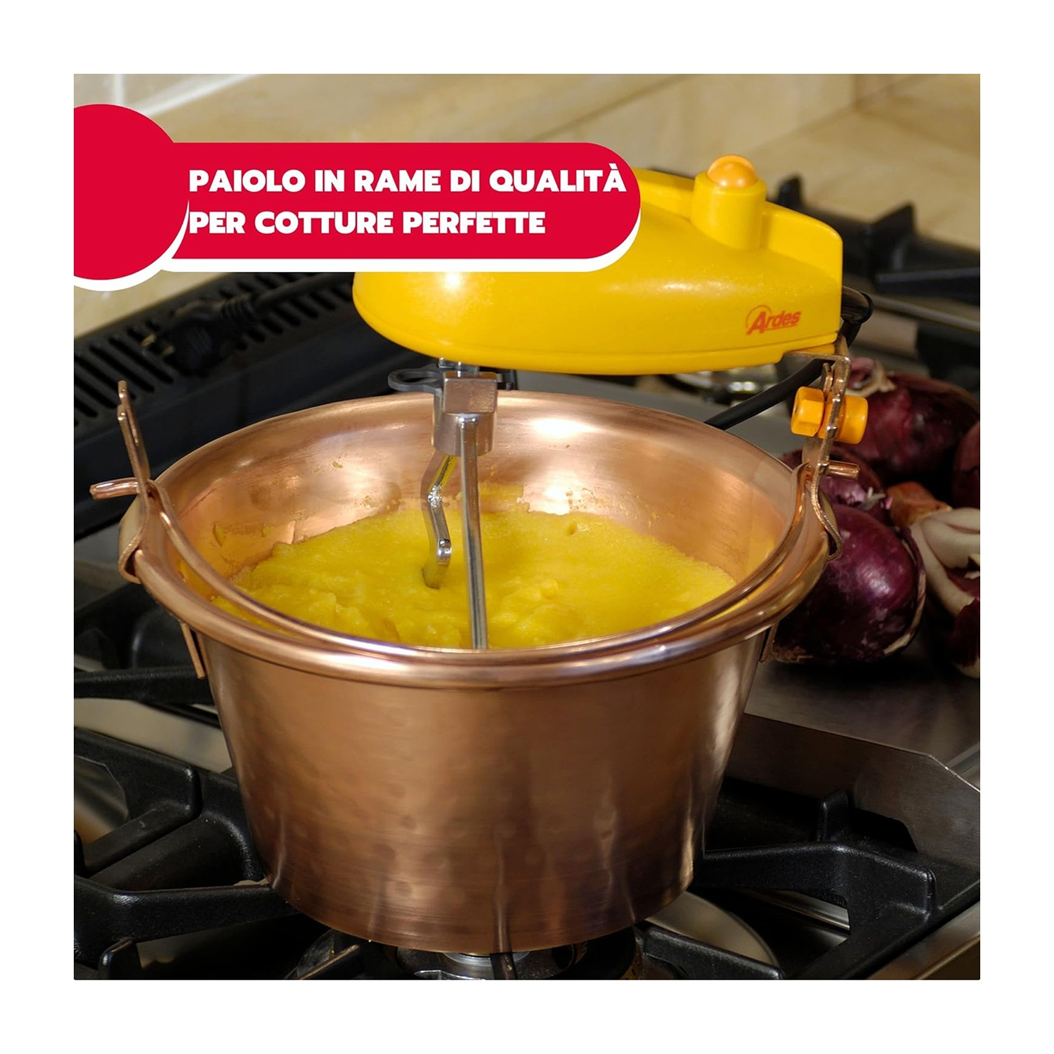 Una pentola di rame con cibo giallo è su un fornello. Una macchina gialla è sopra la pentola. Cipolle sullo sfondo.