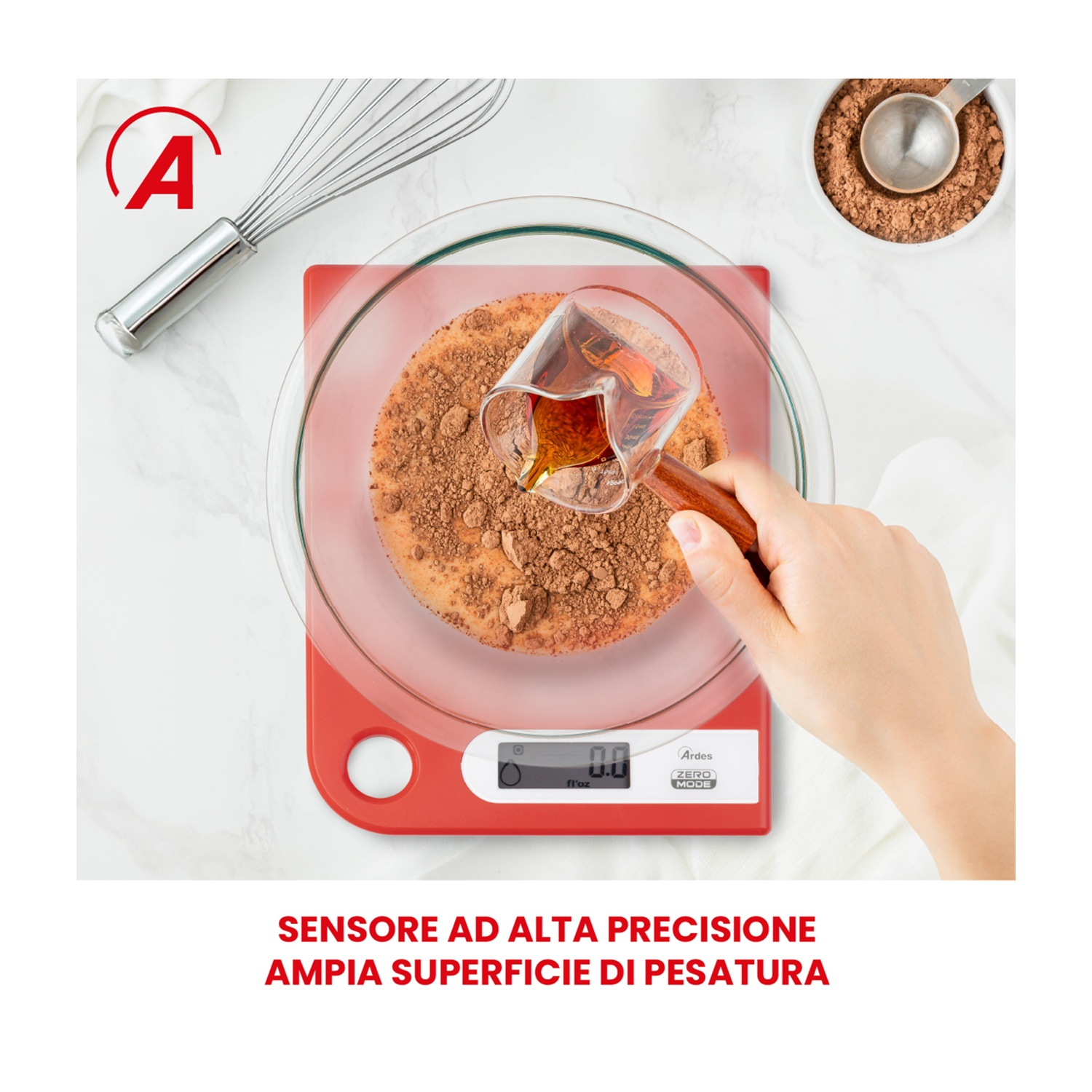 Una mano versa del liquido in una ciotola con cacao in polvere, su una bilancia rossa. Una frusta e una ciotola di polvere sono sullo sfondo.