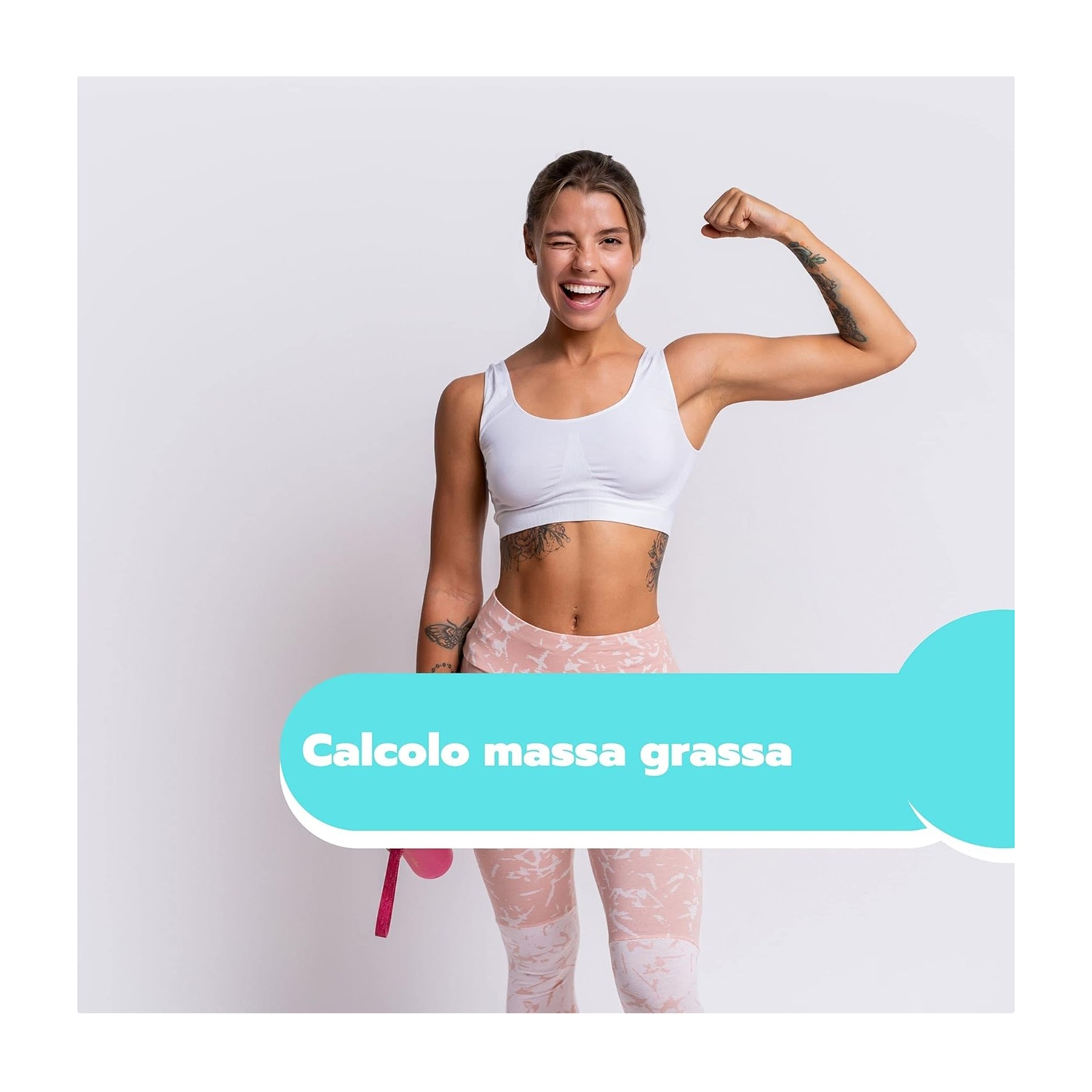 Donna sorride, flette il braccio, indossa reggiseno sportivo e leggings, tatuaggi su braccio e busto, testo: 'Calcolo massa grassa'.