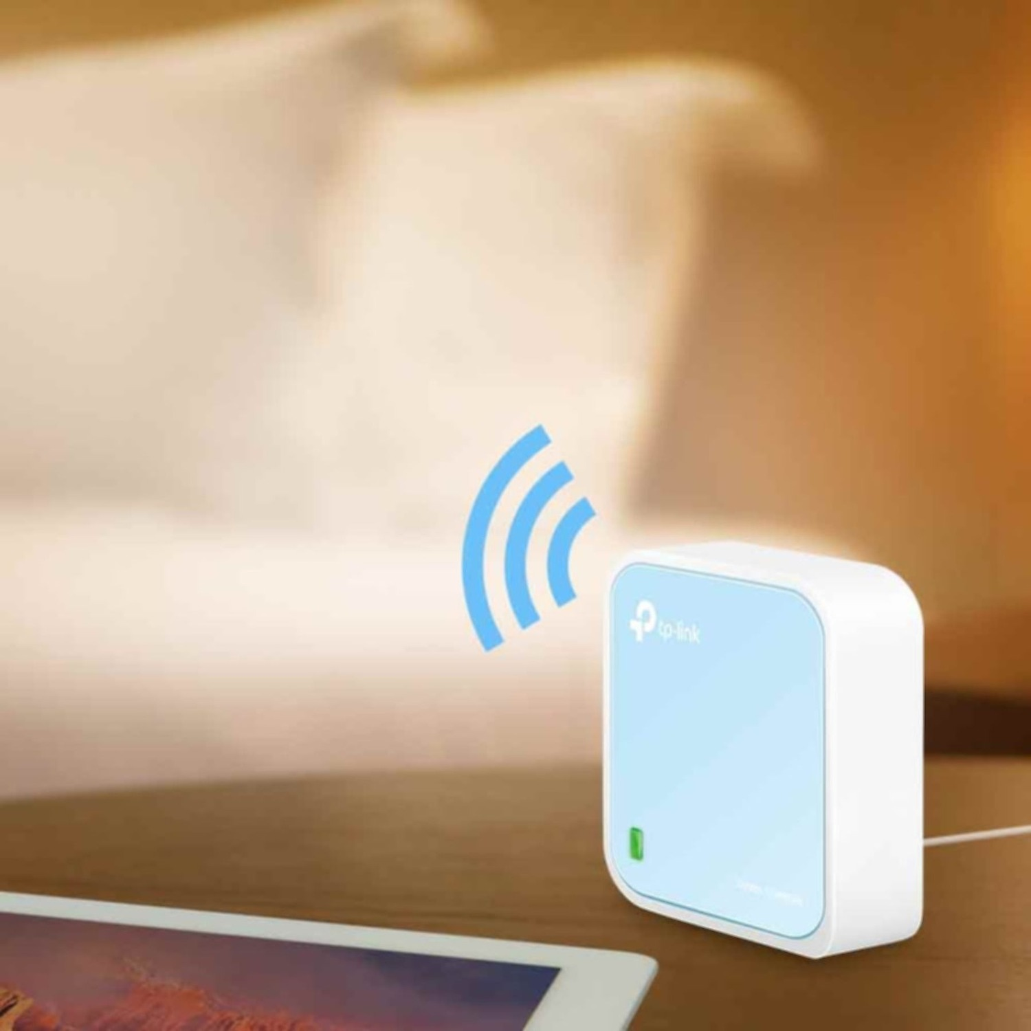 A white and blue TP-Link router sits on a wooden table. A tablet lies in front. Wi-fi signal icon is visible.
