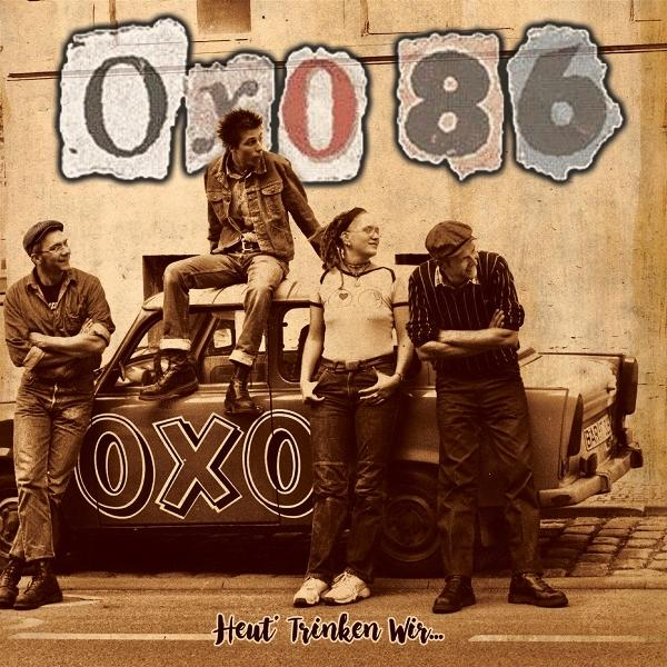 Band Oxo 86 auf einem Auto. Vier Personen posieren mit verschränkten Armen. Auf dem Auto steht Oxo. Der Hintergrund ist eine Wand.