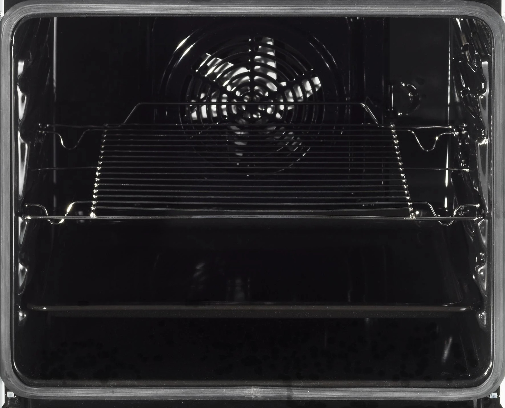 Wnętrze czarnego piekarnika z wentylatorem, dwoma rusztami i światłem. Drzwi piekarnika są otwarte. Wnętrze jest czarne.