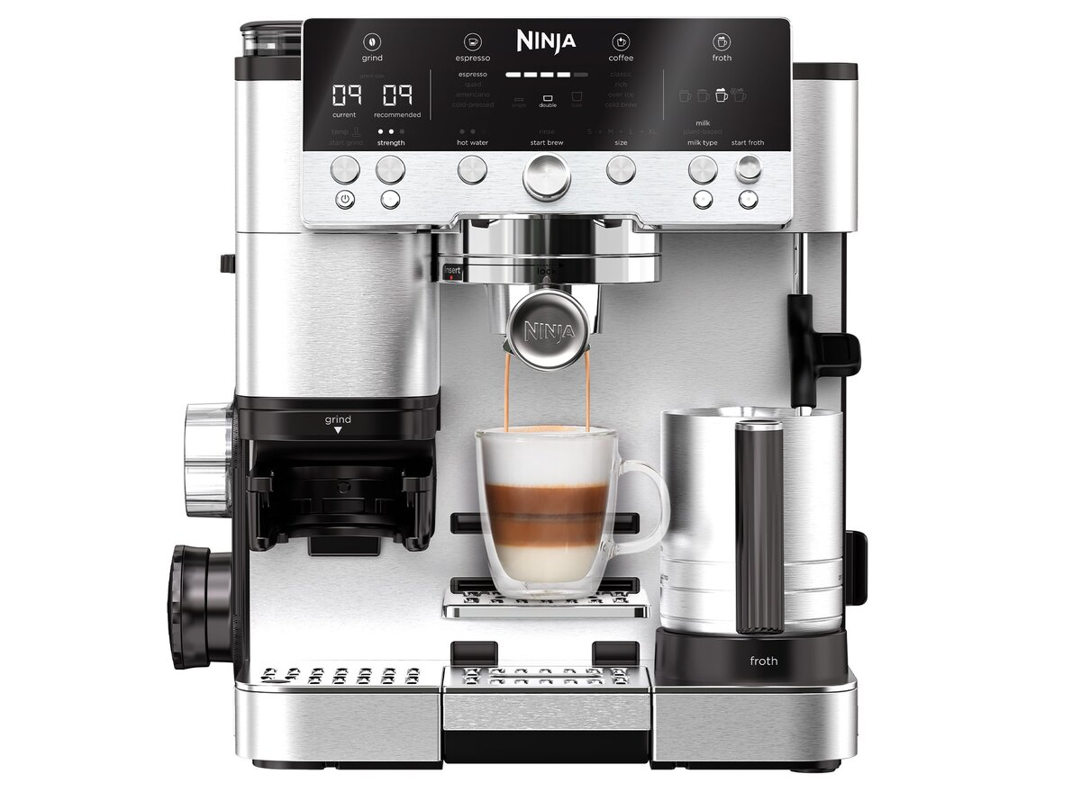 Srebrny ekspres do kawy Ninja ze szklanką warstwowej kawy. Ekspres ma przyciski i wyświetlacz cyfrowy.