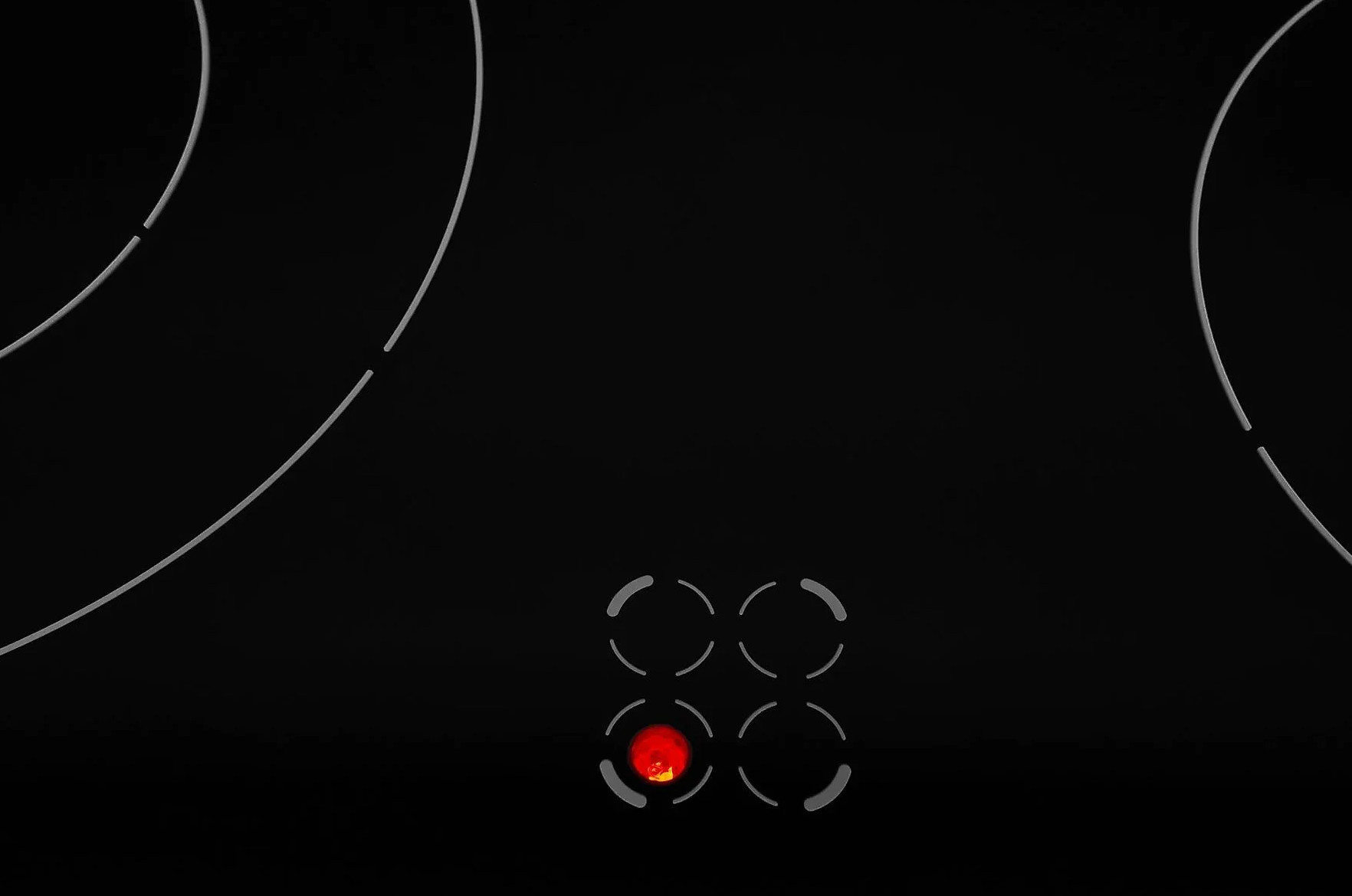 Czarna płyta grzewcza z białymi obrysami. Świeci się czerwona lampka kontrolna. Cztery palniki wskazane liniami krzywymi.