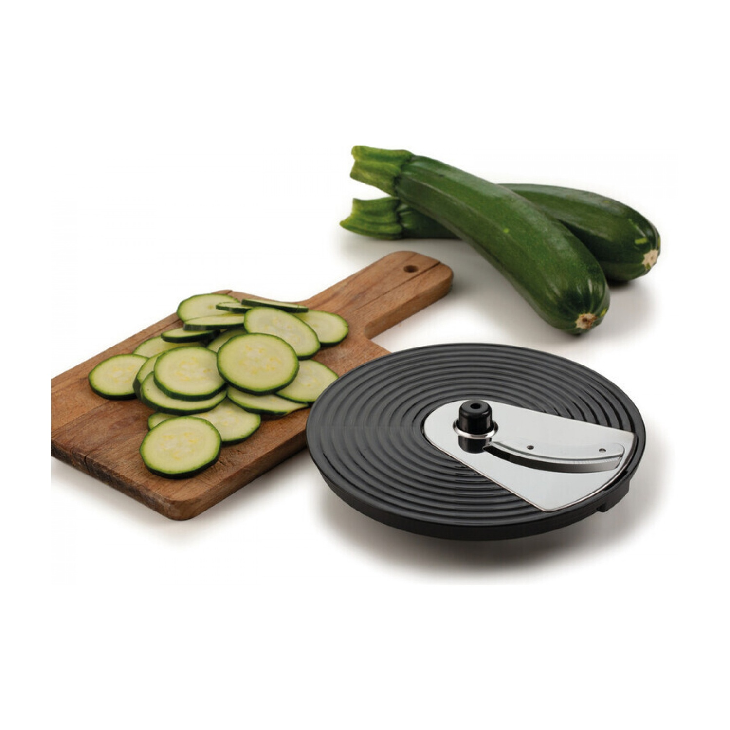 Un tagliere di legno con zucchine a fette, due zucchine intere e un affettatrice nera e argento su una superficie bianca.