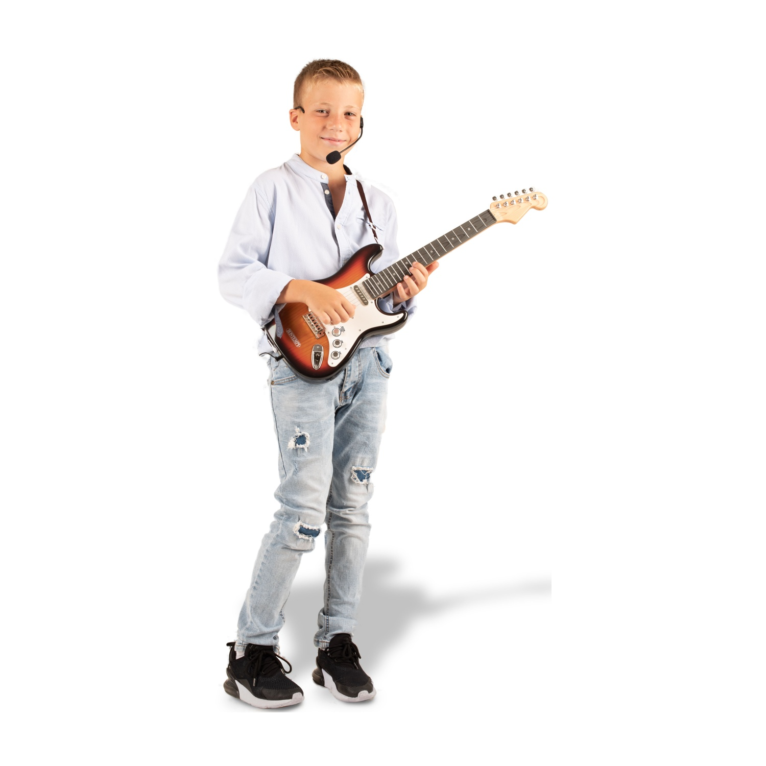 Un ragazzo con un microfono a cuffia suona una chitarra elettrica marrone e bianca. Indossa una camicia azzurra, jeans strappati e scarpe da ginnastica nere.