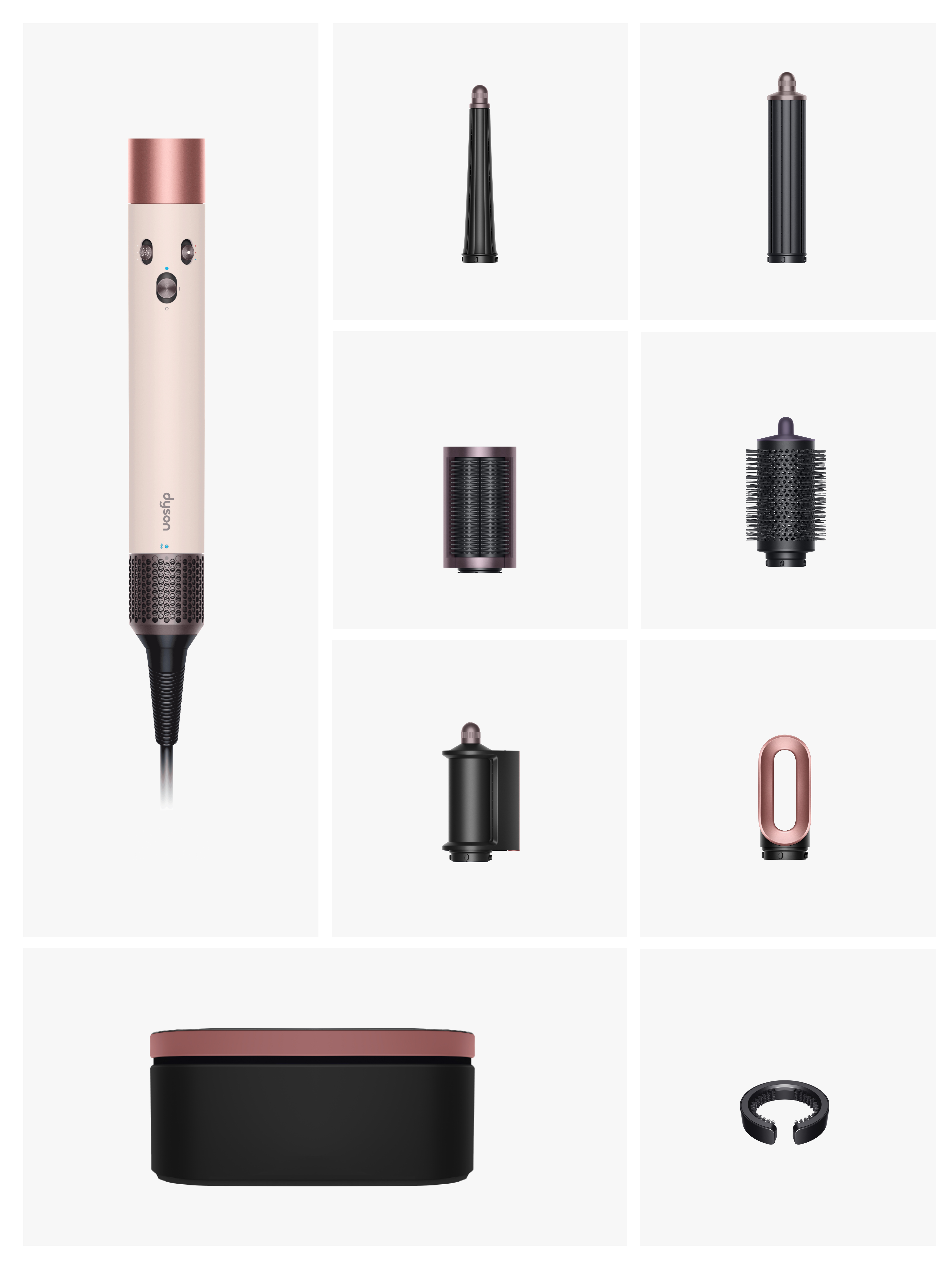 Un moldeador de cabello Dyson y varios accesorios se muestran sobre un fondo blanco. El moldeador es crema y oro rosa.