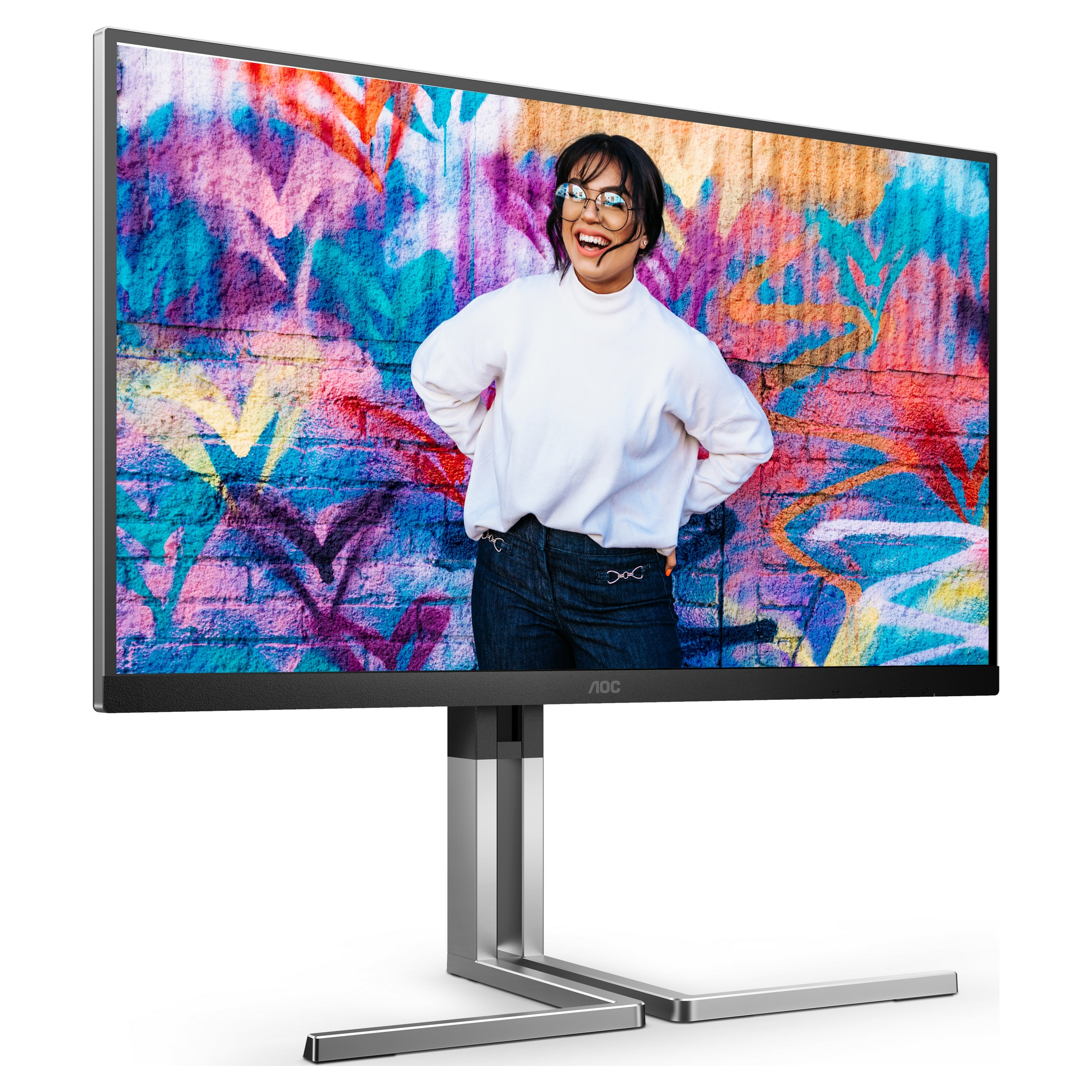 El monitor AOC muestra a una mujer sonriendo frente a una colorida pared de graffiti. Lleva gafas, un suéter blanco y jeans.
