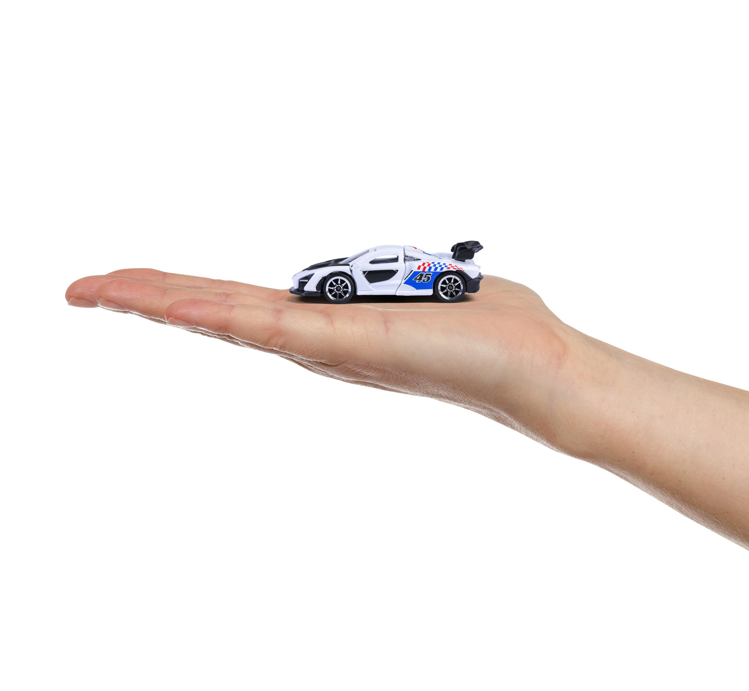 Ein weißes Spielzeug-Rennauto mit schwarzen Akzenten, gehalten in einer offenen Hand, isoliert vor weißem Hintergrund.