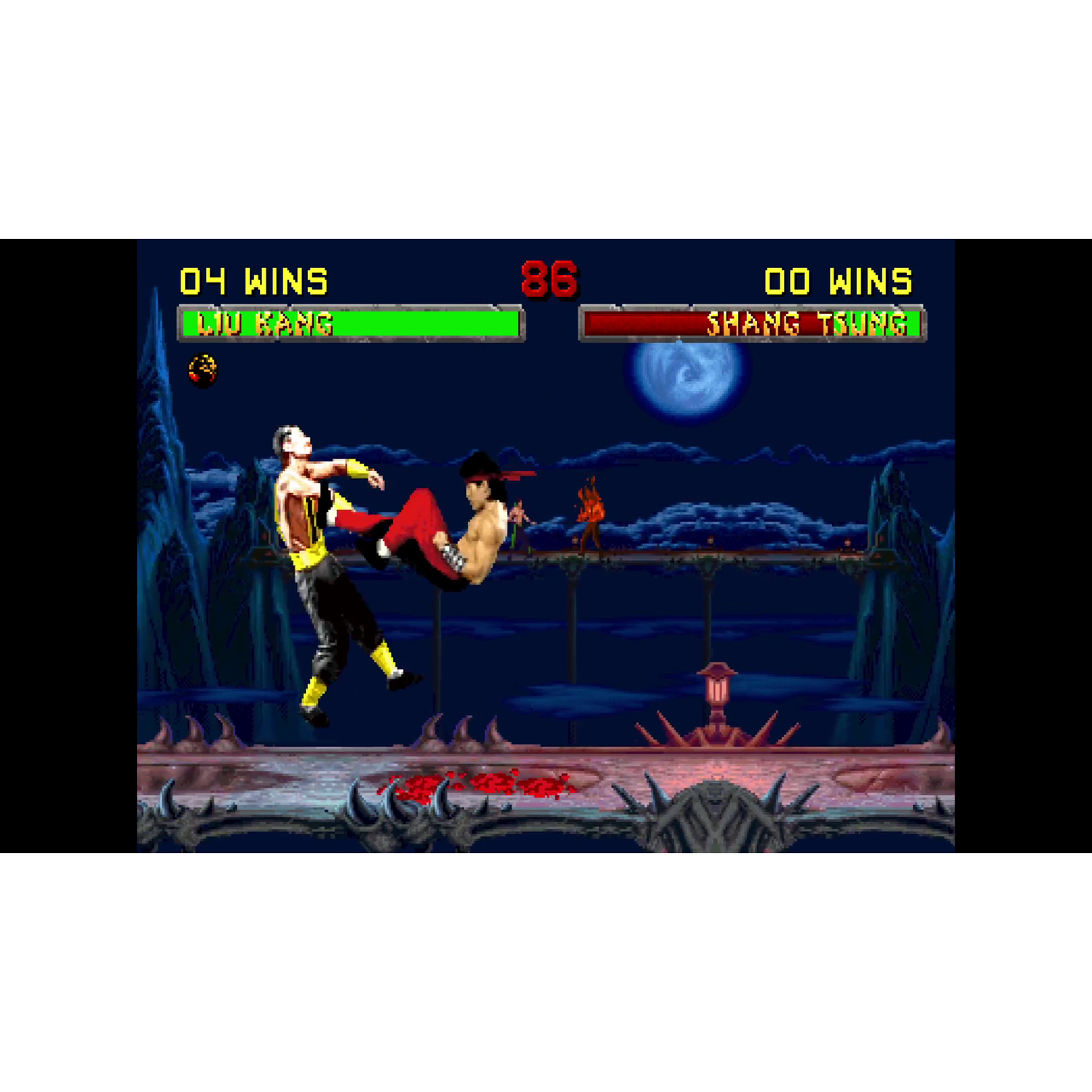 Mortal Kombat scène. Liu Kang schopt Shang Tsung. Scores: 04-00. Achtergrond met nachthemel, maan en spikes.