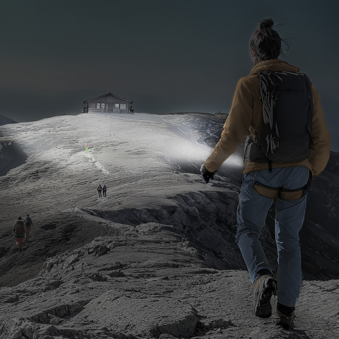 Eine Person wandert nachts mit einer Taschenlampe. Andere Wanderer und eine Hütte sind auf dem Berg zu sehen. Die Szene ist dunkel.
