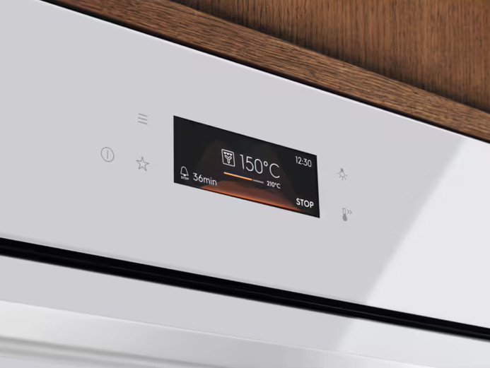 Panel sterowania piekarnikiem z wyświetlaczem cyfrowym. Pokazuje 150°C, 36min i 12:30. Przyciski to start, stop i inne ikony.