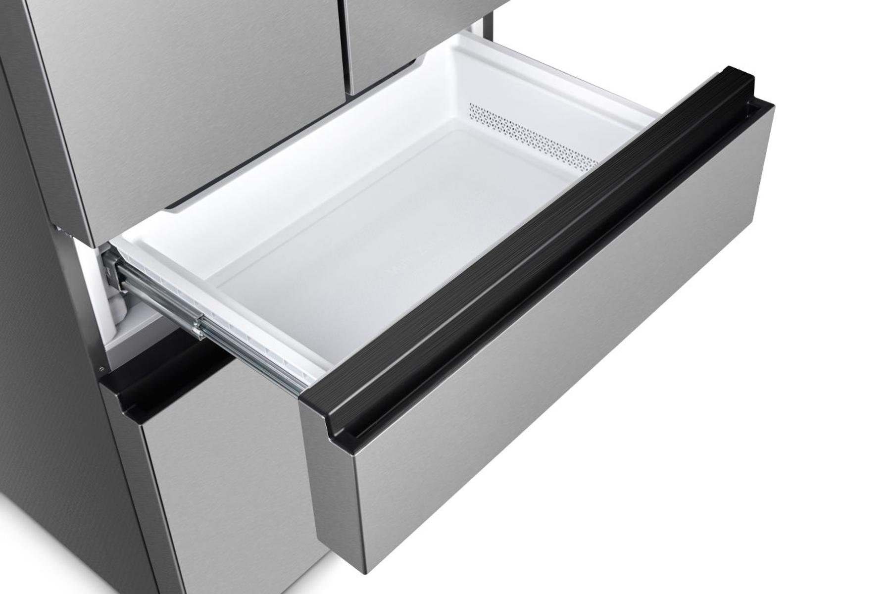 Otwarta szuflada lodówki ze stali nierdzewnej, odsłaniająca białe wnętrze. Szuflada ma czarny uchwyt i znajduje się na białej powierzchni.