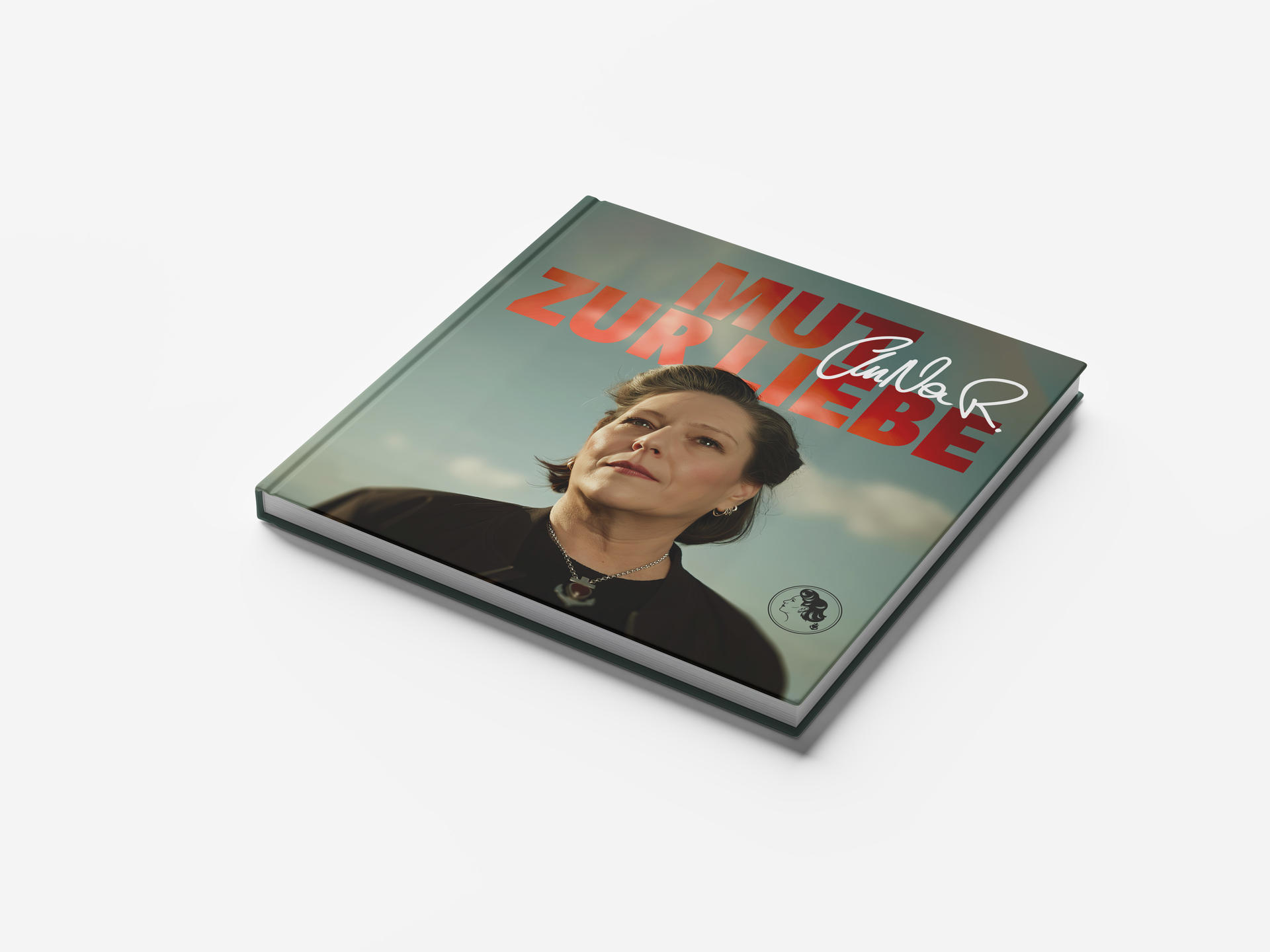 Buchcover mit Frauenporträt, Titel 'Mut Zur Liebe' und Signatur. Hintergrund: Himmel. Buch auf weißer Oberfläche.